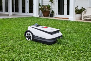 robot tondeuse blanc sur pelouse